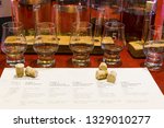 Whisky tasting setup with numbered sampling glasses, beaker and bottles on display.