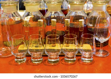 Whisky Tasting Setup With Numbered Sampling Glasses, Beaker And Bottles On Display.