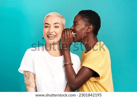 Whisper, secret and girl friends portrait with privacy, laugh and gossip in a studio. Blue background, women and smile of a female person with diversity and funny news telling a story and listening