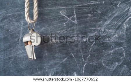 Whistle of a soccer coach or referee on black board with free copy space
