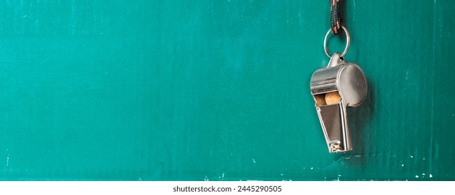 Whistle of soccer referee or coach on green background.Great international soccer event in europe 2024. Panoramic,negative space technique, free copy space. - Powered by Shutterstock