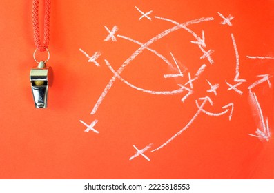 Whistle of soccer referee or trainer and soccer tactics scribble on red background. Great soccer event this year,close up
