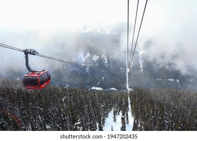 Whistler - Blackcomb, BC. The aerial view on red Peak to Peak gondola during winter time. Snowy forest and mist - fog in the background. March 26, 2021.