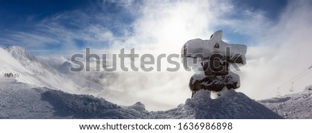 Whistler, British Columbia, Canada. Beautiful Panoramic View of Statue on top of Blackcomb Mountain with the Canadian Snow Covered Landscape in background during a cloudy and vibrant winter sunset.