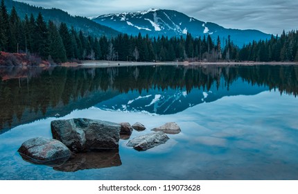 Whistler mountain reflected in lost lake with a blue hue.