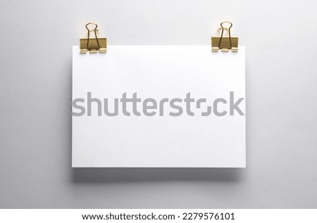 White a4 sheet paper mockup with Golden binders on gray background. Template for design