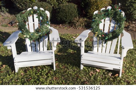 white adirondack chairs decorated with christmas holiday wreaths on front lawn in sunshine horizontal - Decorating Adirondack Chairs For Christmas white adirondack chairs decorated with christmas holiday wreaths on front lawn in sunshine horizontal - Decorating Adirondack Chairs For Christmas