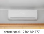 White Air Conditioner Mini Split Unit Mounted at Wall in Room