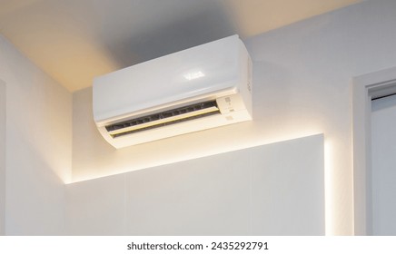 White air conditioner mounted on the wall inside the house