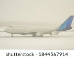 white airplane taking off in heavy snoy with snoing background(color edited)