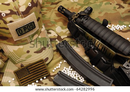 White airsoft bullets and sub-machine gun on multicam background