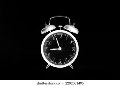 White Alarm Clock Isolated On Black Background. 9 O'clock. Morning, Reminder. Time Concept. Shot In Inversion Mode