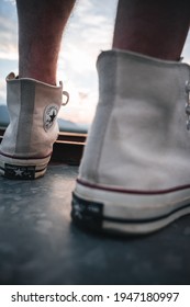 White All Star Sneakers On Top Of A Water Tower During Sundown