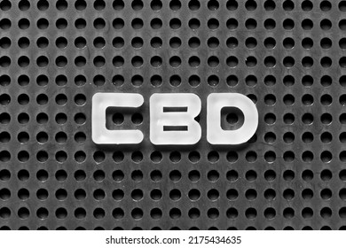 White alphabet letter in word CBD (Abbreviation of Central business district or Cannabidiol) on black pegboard background