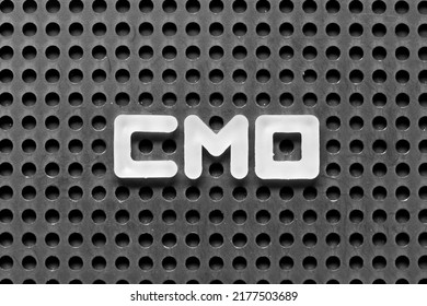 White Alphabet Letter In Word CMO (Abbreviation Of Chief Marketing Officer, Contract Manufacturing Organization) On Black Pegboard Background