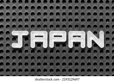 White Alphabet Letter In Word Japan On Black Pegboard Background