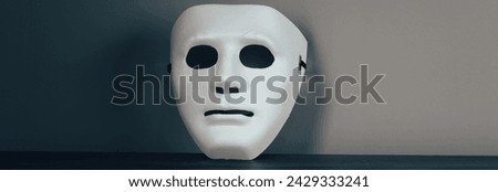 White anonymous mask on a wooden table
