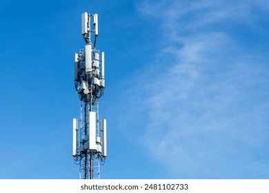 White antennas on cell tower close-up. Mobile data transmission tower with antennas against a blue clear sky, concept of telecommunications equipment, Future 6G high-speed mobile.