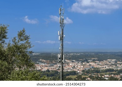 White antennas on cell tower close-up. Mobile data transmission tower with antennas against a blue sky and city in the background, concept of telecommunications equipment, Future 6G high-speed mobile. - Powered by Shutterstock