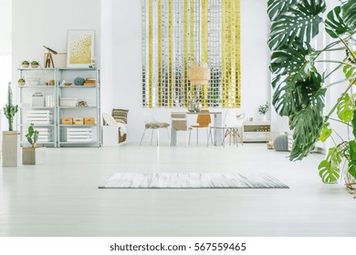 White Apartment With Metal Bookcase, Table, Chairs And Rug