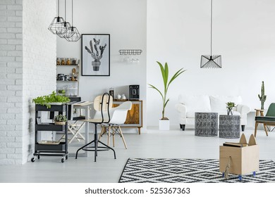 White apartment with pattern carpet, brick wall, table and sofa