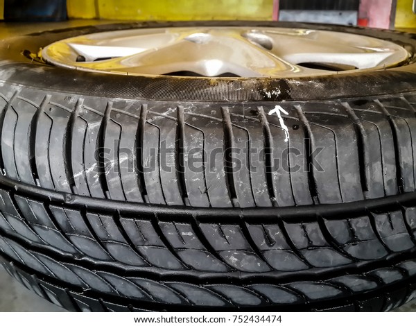 white arrow mark the leaking point on car tire.\
sometimes the leaking can not be seen with bare eyes, tire must be\
checked by putting under water and see air bubble and mark the\
position for repair.
