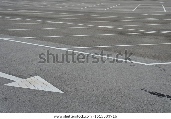 The white arrows indicate the direction of traffic\
on the empty parking lot.