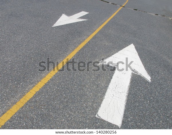 White\
arrows pointing in opposite directions on\
street