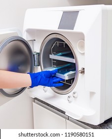 White Autoclave In Sterilization Room In Clinic. System To Sterile Steel. Surgical And Dentistry Equipment. Medical Instruments. Blue Gloves 