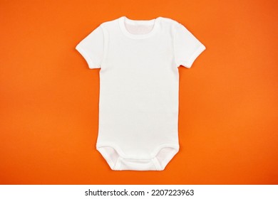 White Baby Girl Or Boy Bodysuit Mockup Flat Lay On Orange Background. Design Onesie Template, Print Presentation Mock Up. Top View. 