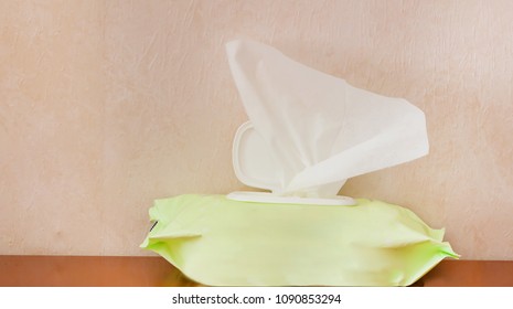 White Baby Wipes, Tissue Box, Wet Wipes In Green Package Box On Wooden Table With Copy Space Background.