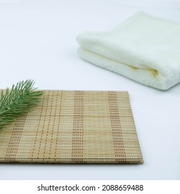 White backdrop with wood props and green pine leaves with soft towel back, Texture Background, Suitable for Product Presentation Backdrop, Display, and Mock up.