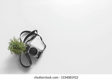 White Background with a Camera and Small Pot
