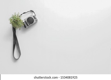 White Background with a Camera and Small Pot
