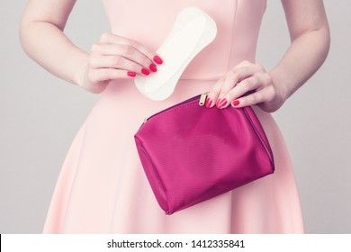 White Background, Girl Holding A Cosmetic Bag And Sanitary Pad, Female Hands, Close Up, Hygiene Concept