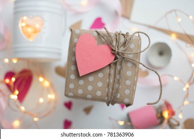white background with modern gift wrapping. doted craft gift. present box with heart label tag with copy place and heartes for valentine's day on a white background with a garland
