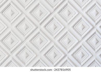 A white background with a pattern of squares and diamonds. The squares are arranged in a way that creates a sense of symmetry and balance. The diamonds add a touch of elegance