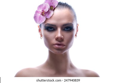 White background. Spring Girl with Flowers Hair Style. Beauty Creative portrait. Young model with great skin wearing orchid. Nature Summer Hairstyle. Holiday Creative Makeover. Fashion Makeup. Make up
