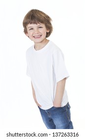 White background studio photograph of young happy boy smiling wearing blue denim jeans hands in pockets