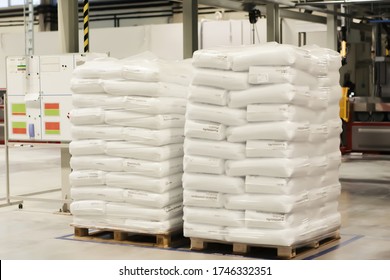 white bags evenly and neatly folded onto a pallet stand in a warehouse for storing consumable plastic materials