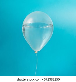 White Balloon With Water On Pastel Blue Background. Creative Minimal Concept.