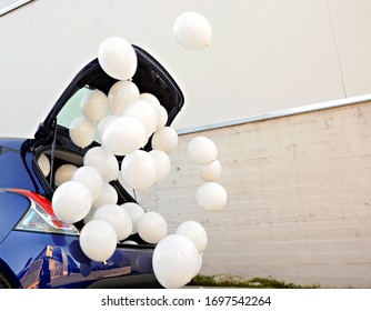 White Balloons Fly From The Car Door