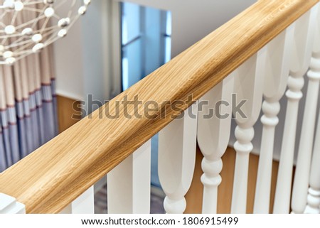White balustrade. Balcony wooden railing with white balusters in a bright large room
