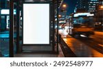 white banner light box for media advertisement at a bus stop on a city street at night, city lights and traffic in the background