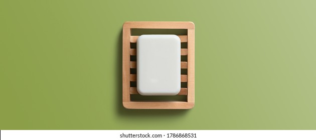 White Bar Of Soap In Wooden Dish On A Green Background. Top View, Flat Lay.