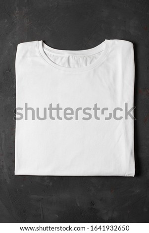 White basic t-shirt on concrete background. Top view. Mockup for branding.