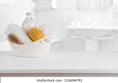 White basket with spa products on wooden table inside bathroom - Powered by Shutterstock