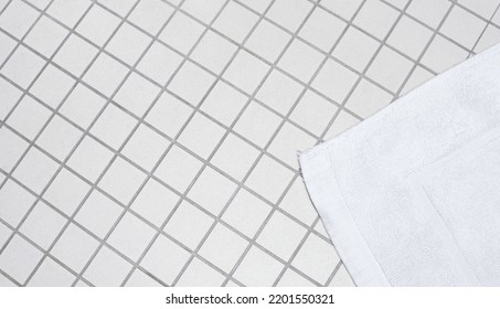 White Bath Mat On The Tile In Shower Room. Bathroom Floor Background.