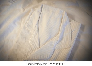 White bathrobe on hotel bed. June 10, 2024