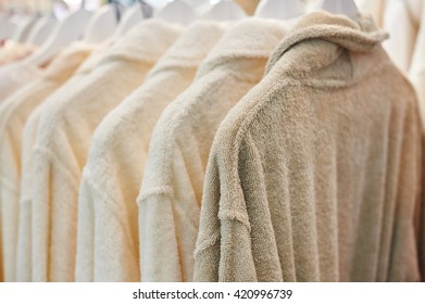 white bathrobes hanging in wooden closet - Powered by Shutterstock